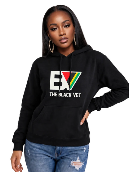 A woman modeling a black pullover hoodie with a large 'BV THE BLACK VET' graphic on the chest, paired with distressed blue jeans against a plain white background.